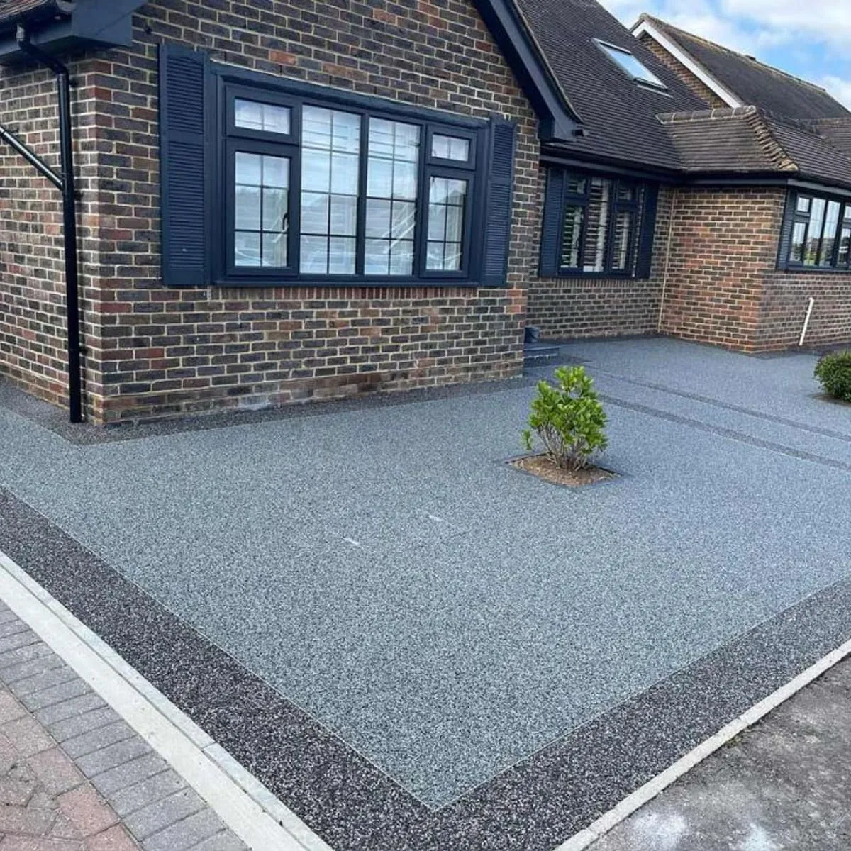Grey resin driveway with a block paved border