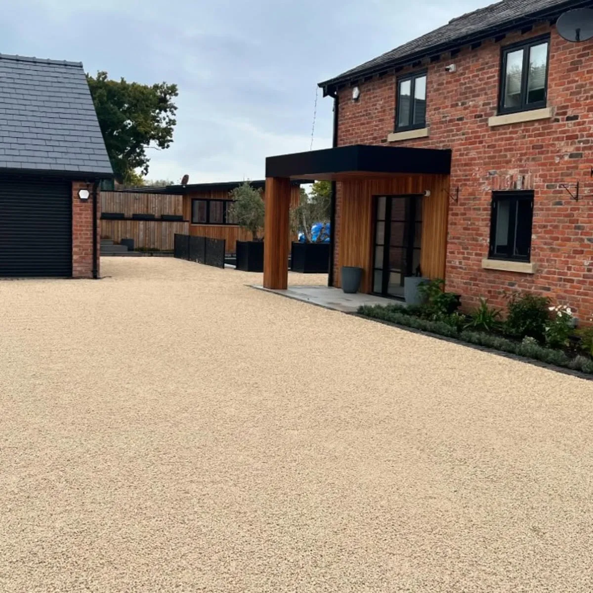 Gravel driveway to a modern brick house