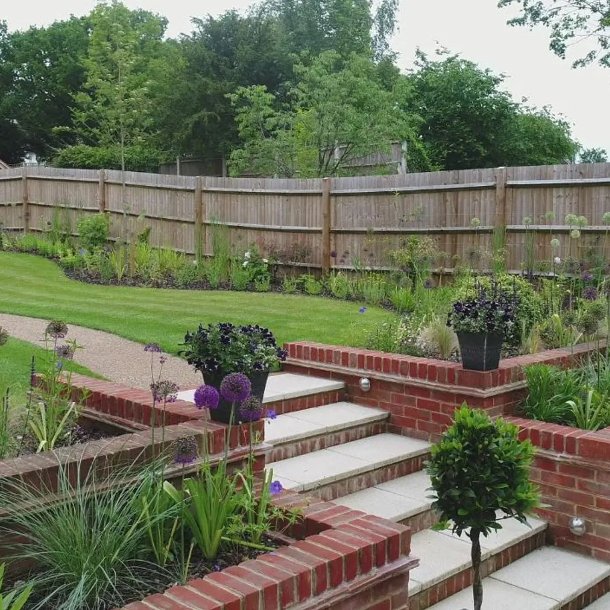 Tiered brick retaining walls with planted borders, built by JR Landscapes & Driveways
