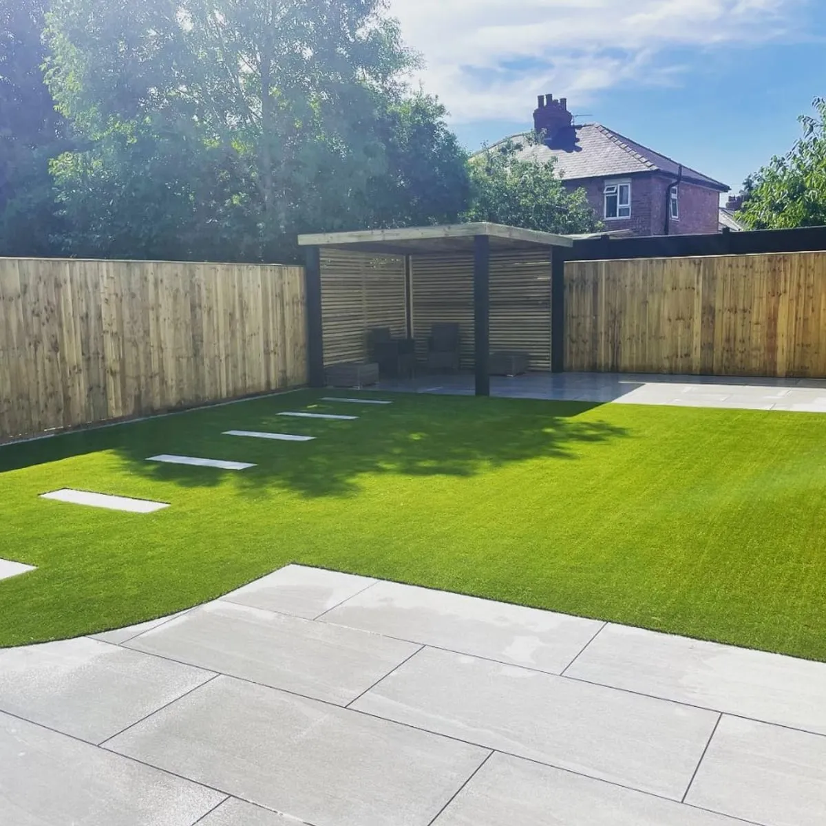 Artificial grass and porcelain paving in an enclosed garden