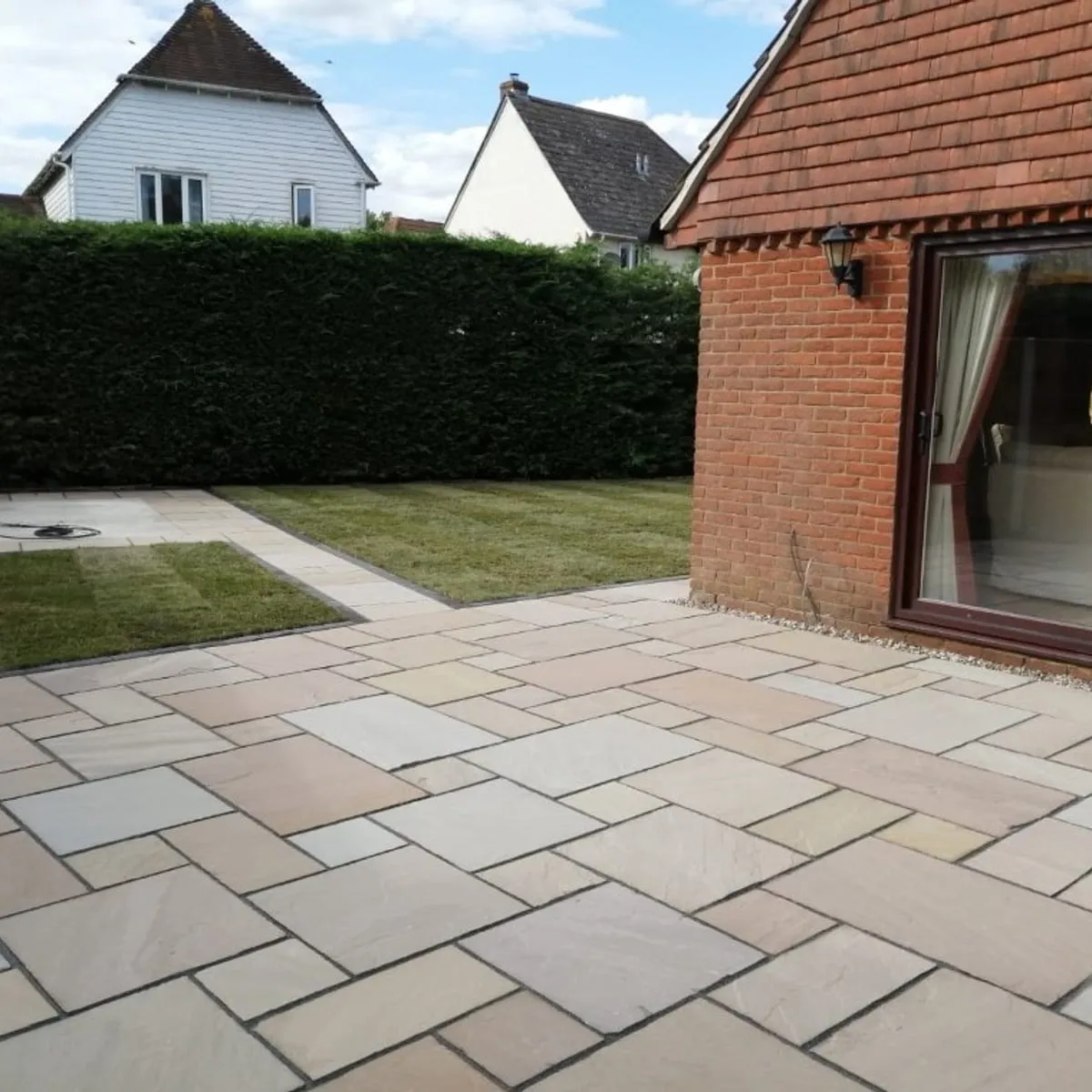 New indian sandstone patio beside a bungalow