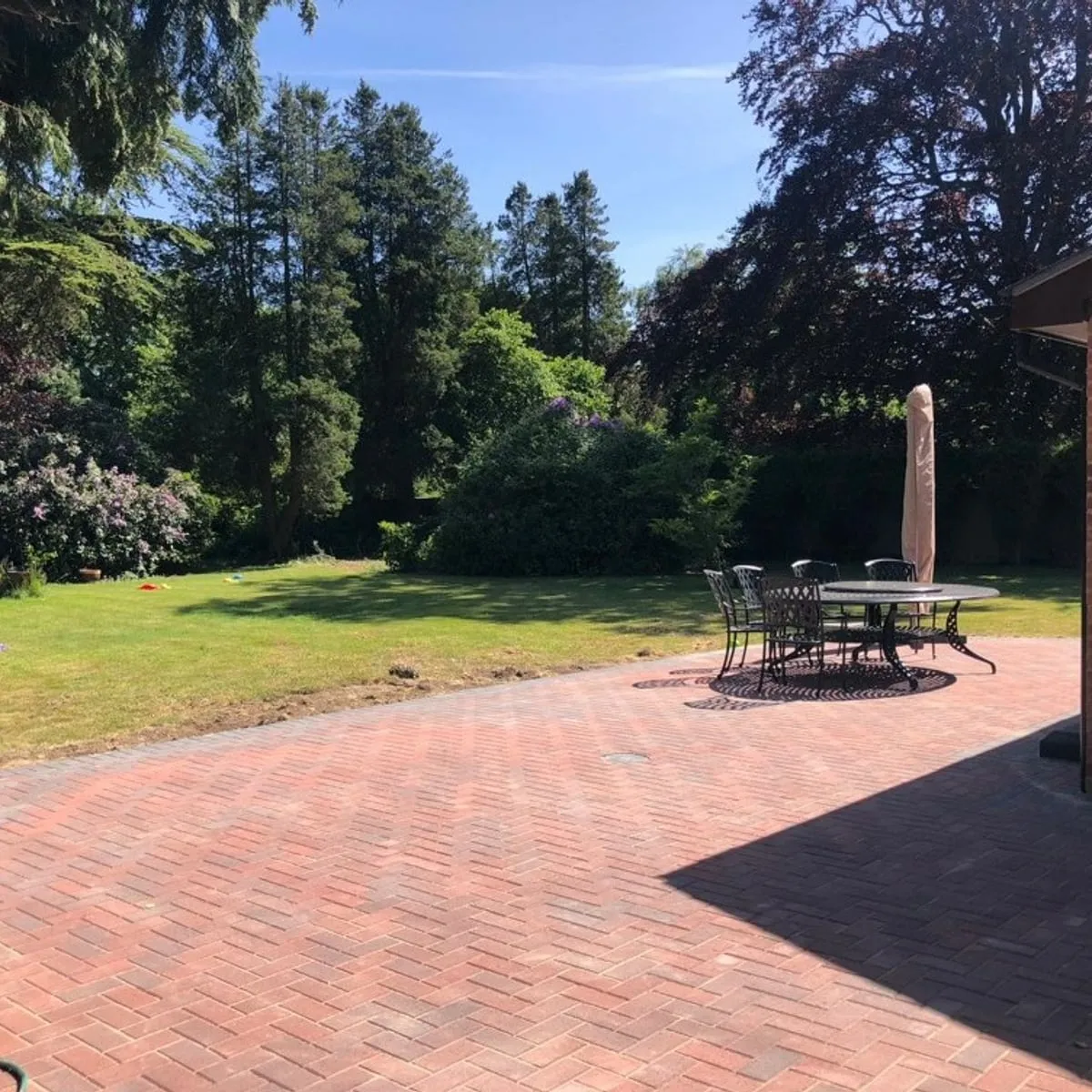 Red block paved patio with a table and chairs