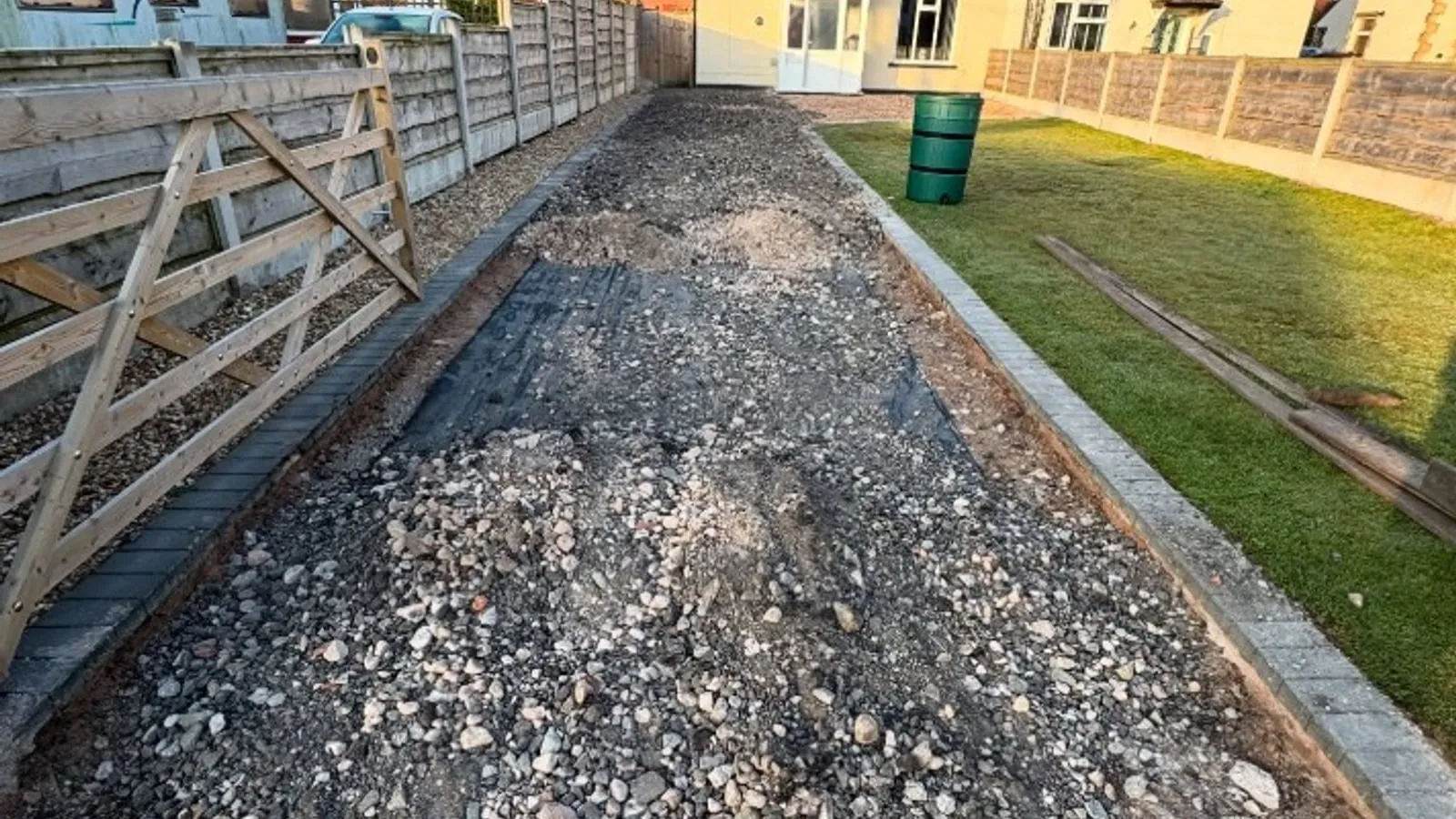 A driveway excavated and filled with compacted stone sub-base before surfacing